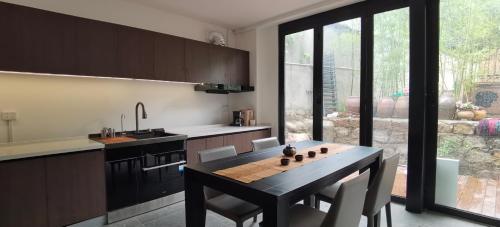 华阴Hidden Spring Entire 7 Bedroom Mountain Villa Near Huashan for Families and Groups的厨房配有桌子、椅子和窗户