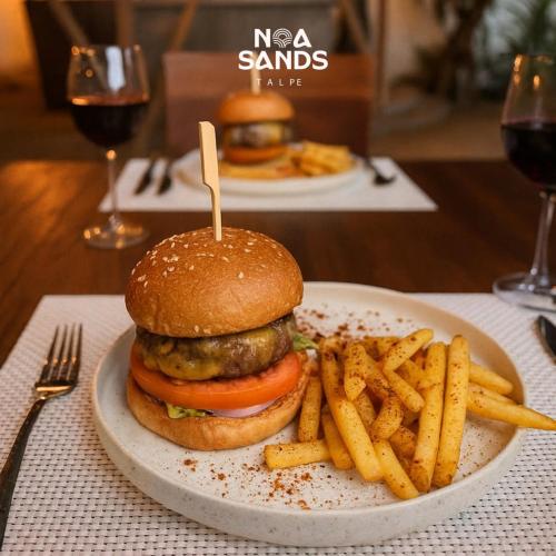 タールにあるNoa Sands By Ceylon Vistasの食卓にハンバーガーとフライドポテトを盛り付けた皿