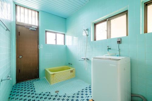 une salle de bain bleue avec un lavabo et une douche dans l'établissement Kumi No Yado Gettou - Vacation STAY 31704v, à Kadekaru