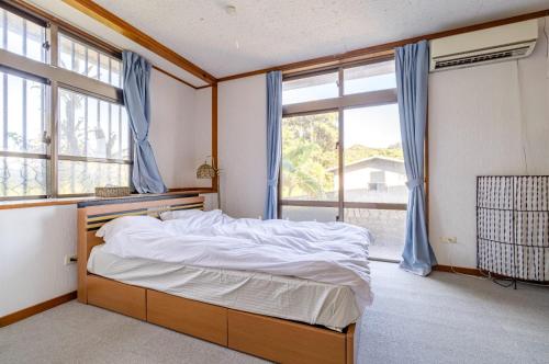une chambre avec un lit et une grande fenêtre dans l'établissement Kumi No Yado Gettou - Vacation STAY 31704v, à Kadekaru