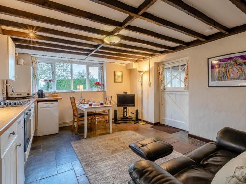 a kitchen and living room with a couch and a table at Orchard Cottage - Uk30437 in Kingsbury Episcopi