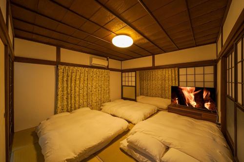a bedroom with two beds and a tv at Yufu no Yu Raku - Vacation STAY 18768v in Yufuin