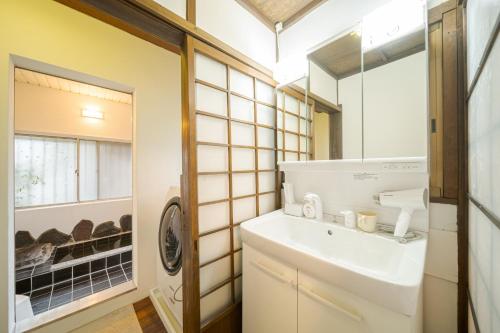 a bathroom with a sink and a washing machine at Yufu no Yu Raku - Vacation STAY 18768v in Yufuin
