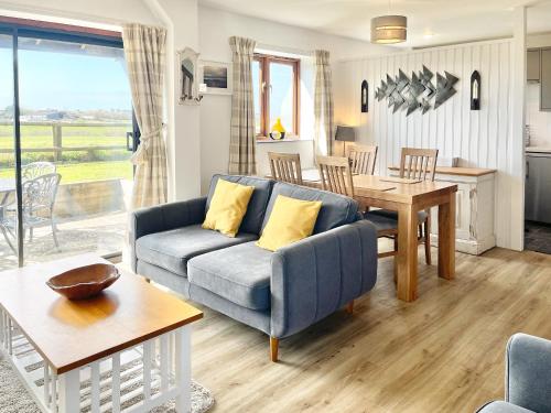 a living room with a blue couch and a table at Harvest Cottage in Padstow