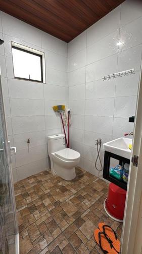 a bathroom with a toilet and a sink at D'Kebun Lenggong Perak Chalet in Kampong Ulu Jepai