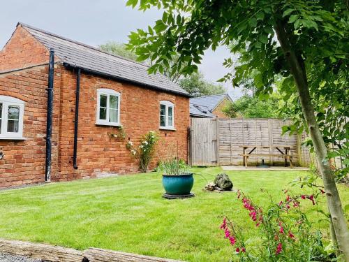 a small brick house with a yard with a yard at The Parlour in Earls Croome