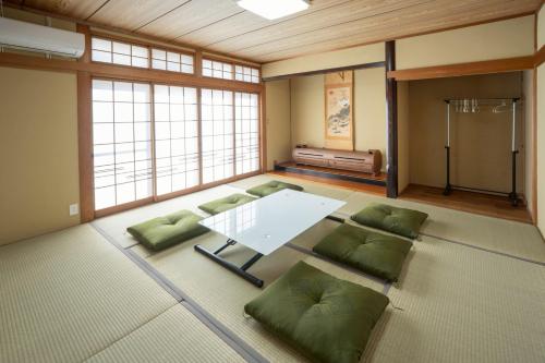 a large room with a table and green pillows at 晴宿-Hareyado 