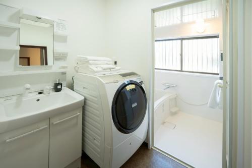 a white bathroom with a washing machine and a sink at 晴宿-Hareyado 