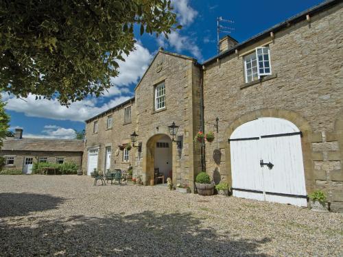 an old stone building with a white garage at Carriage House - E5119 in West Burton