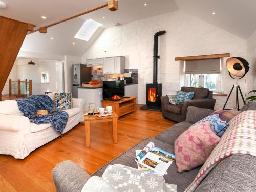 a living room with two couches and a fireplace at The Loft - Cottage in Letterston