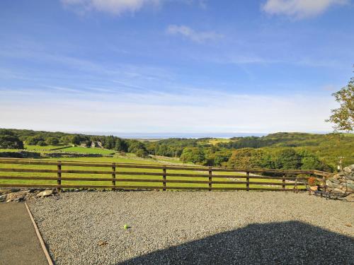 a wooden fence with a view of the countryside at Cwm Nantcol Barn in Llanbedr