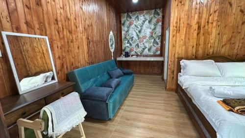 a room with a couch and a bed and a chair at D'Kebun Lenggong Perak Chalet in Gua Sai