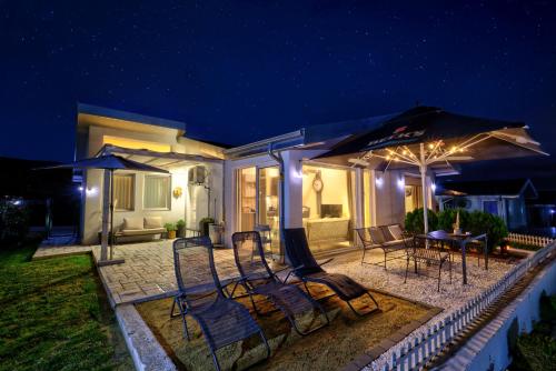 a patio with chairs and umbrellas at night at villas 21,22 Albena sea view in Rogachevo