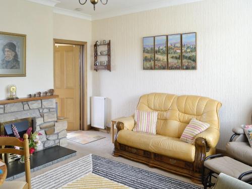 a living room with a couch and a fireplace at Anchorage in Maidens