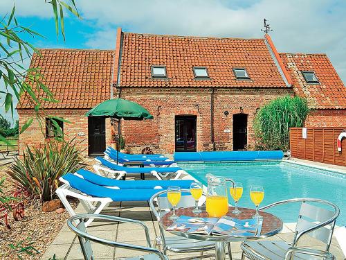 a patio with chairs and a table with wine glasses at Timbers Barn - E3863 in Runcton Holme