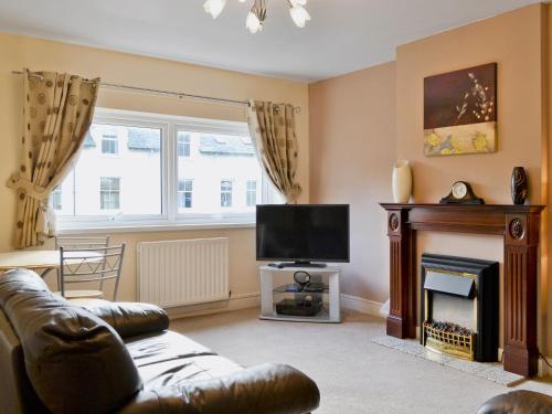 a living room with a couch and a fireplace at Serendipity in Keswick