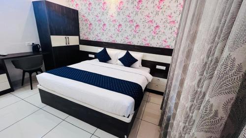 a bedroom with a bed with blue and white sheets at The lawrences aqua stay in Cochin