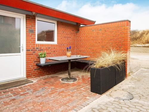 a table sitting in front of a brick wall at 5 person holiday home in Henne-By Traum in Henne Strand