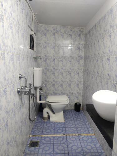 a bathroom with a toilet and a sink at Rodrigues Guest House in Calangute