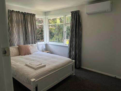 a bedroom with a white bed with a window at Darfield Hotel Apartment Home in Darfield