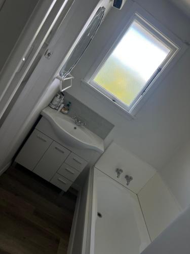 a bathroom with a sink and a window at Darfield Hotel Apartment Home in Darfield
