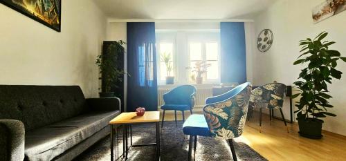 クレムス・アン・デア・ドナウにあるOase Krems - Perle der Wachauのソファと椅子とテーブルのあるリビングルーム