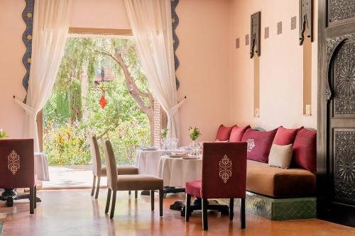 马拉喀什美丽典费斯酒店的带桌子和沙发的餐厅