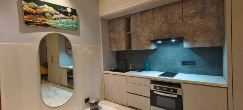 - une cuisine avec un évier et un miroir dans l'établissement Blue Sapphire Forest Stays, à Ghaziabad