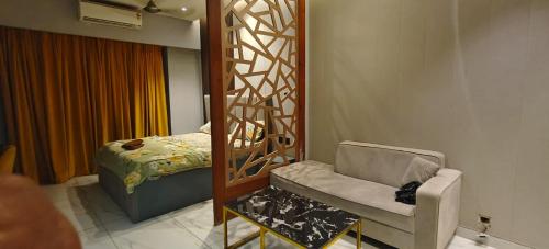 Cette chambre comprend un lit, une chaise et un miroir. dans l'établissement Blue Sapphire Forest Stays, à Ghaziabad