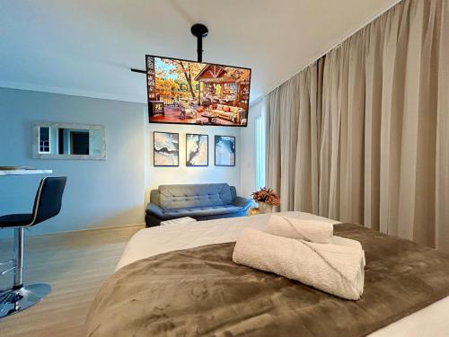 a bedroom with a large bed and a couch at Studio Sofisticado 2106 - Próx Aeroporto GRU in Guarulhos