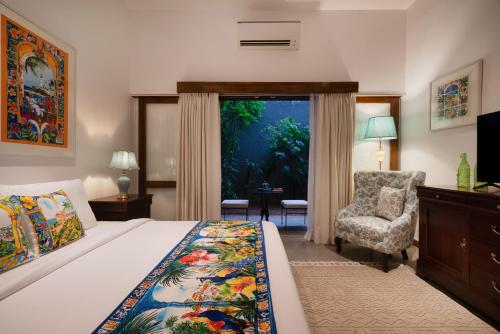 a bedroom with a bed and a chair and a window at Luna Mews - Ward place in Meda-Ela