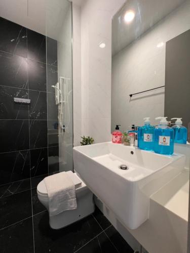 a white bathroom with a sink and a toilet at Georgetown#Beacon Executive Suite SkyPool#Modern & Elegant Suite# in George Town