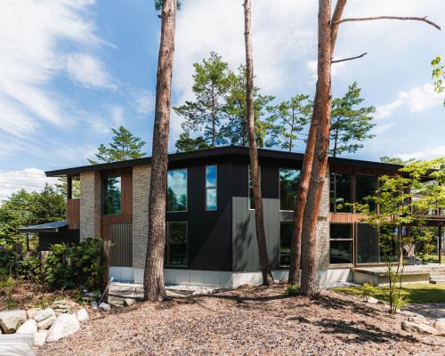 a house in the woods with trees at Base 47 Hakuba by Jade Group in Hakuba