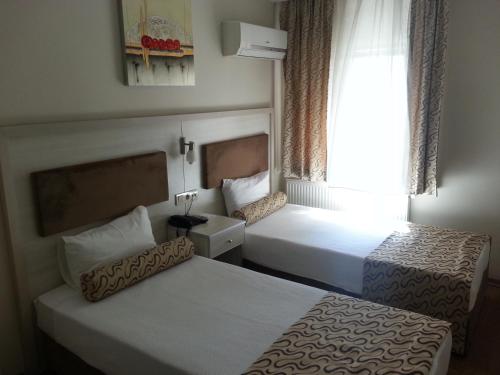 a hotel room with two beds and a window at Grand Zeybek Hotel in Izmir
