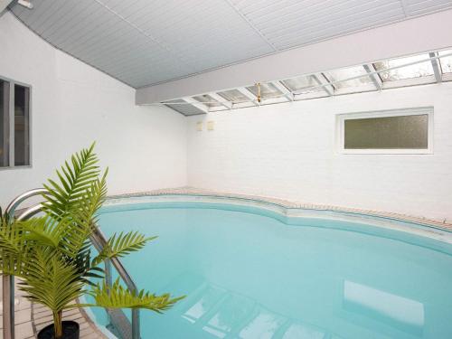 a large swimming pool in a building with a large blue pool at 8 person holiday home in Ørsted-By Traum in Kare
