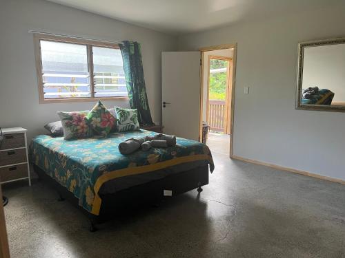Un dormitorio con una cama, una ventana y un espejo. en Mareva Kore, en Avarua
