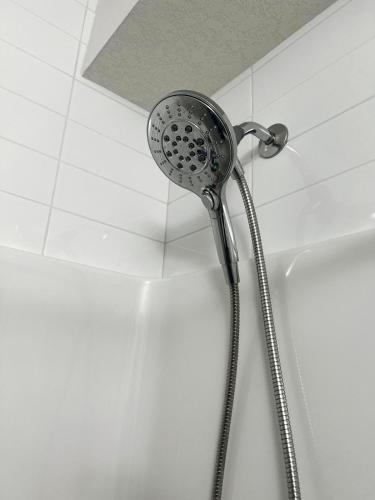 a shower head is attached to a wall at Peaceful Homes - Elegant 2 Bedroom Suite in Calgary