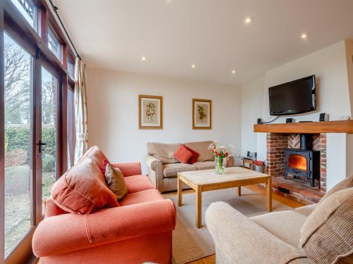 SculthorpeにあるKestrel Barn - Culの2つのソファと暖炉のあるリビングルーム
