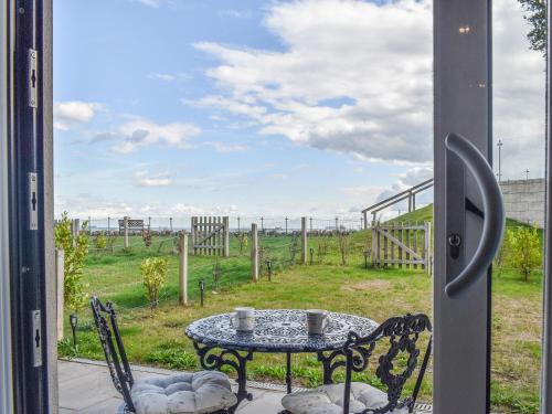 een tafel en stoelen op een patio met uitzicht op een veld bij Seascape in Sandown