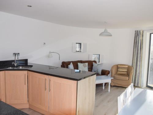 a kitchen with a counter and a living room at Sea Drift in West Bay