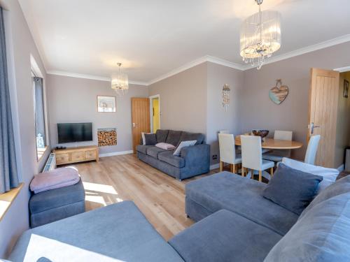 a living room with blue couches and a table at Beach Haven - Uk42241 in Littlestone-on-Sea