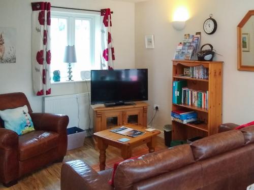 un salon avec un canapé et une télévision dans l'établissement Meadow View, à Bridlington