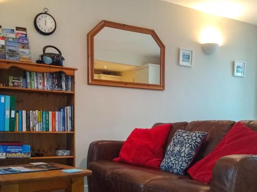 - un salon avec un canapé brun et un miroir dans l'établissement Meadow View, à Bridlington