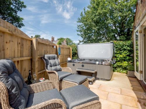 a patio with chairs and a big screen tv at The Chicken Coop in Fulletby