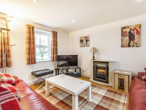 a living room with a couch and a fireplace at Cobble Cottage - Uk38973 in Whitby