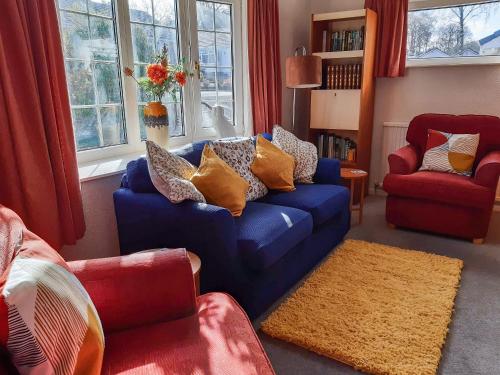 a living room with a blue couch and two chairs at Peel Wyke in Keswick