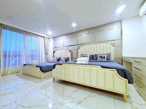 a bedroom with two beds and a flat screen tv at ปาล์มสปริง by Nimo villa pattaya in Ban Nong Pru