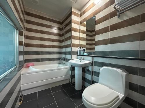 SongjŏngにあるGyeongpo Iris Stayのトイレ、洗面台、浴槽を備えたバスルーム