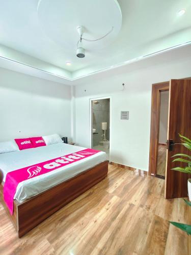 a bedroom with a large bed and a wooden floor at Atiti Signature room 109 , zero mile in Patna