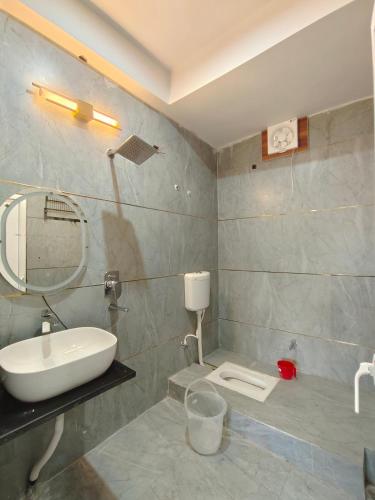 a bathroom with a sink and a mirror at Atiti Signature room 109 , zero mile in Patna